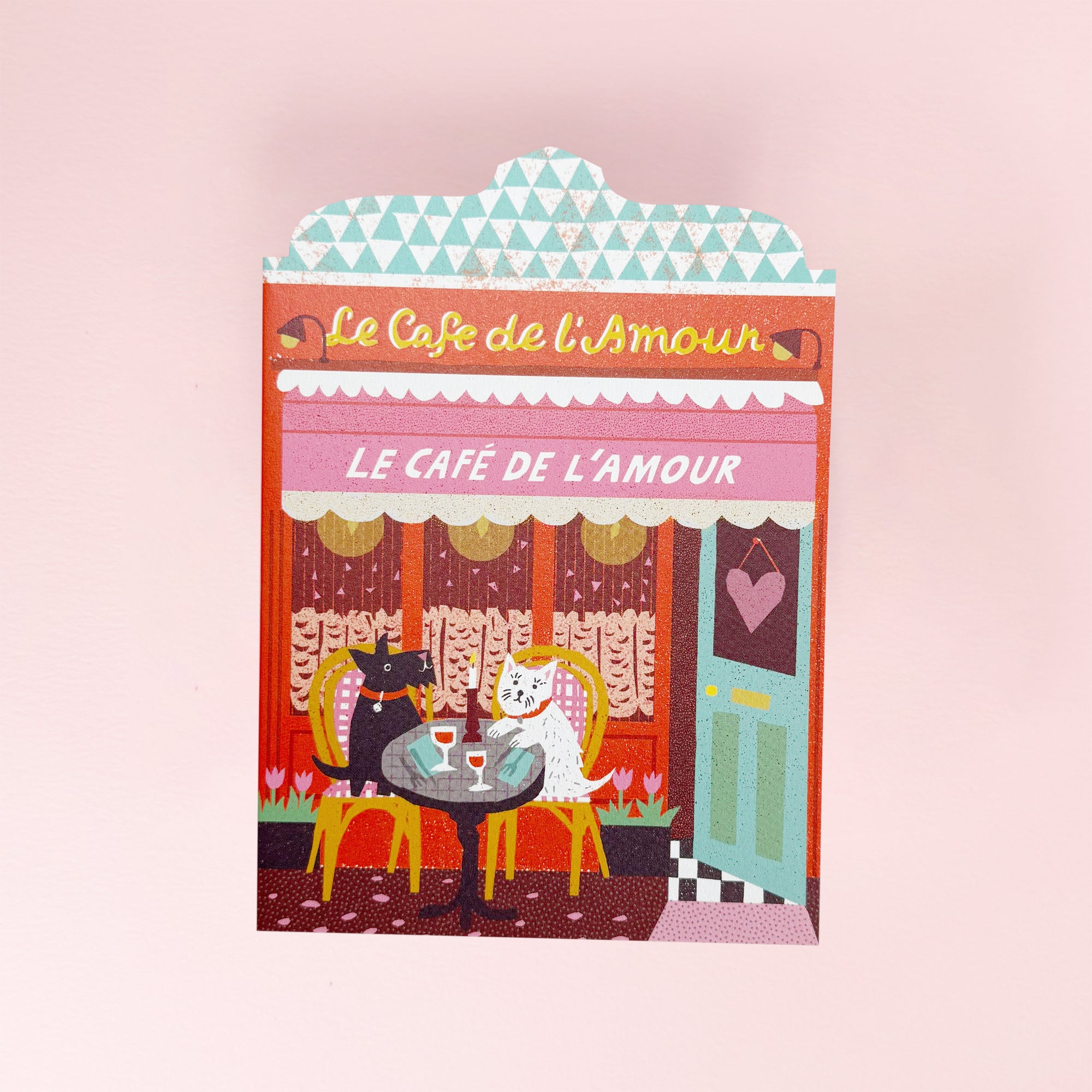 Greeting card Illustration of a café named 'Le Café de l'Amour' with two dogs at a table.