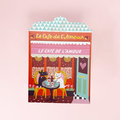 Greeting card Illustration of a café named 'Le Café de l'Amour' with two dogs at a table.