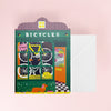 Card with bicycle-themed design and envelope on a pink background